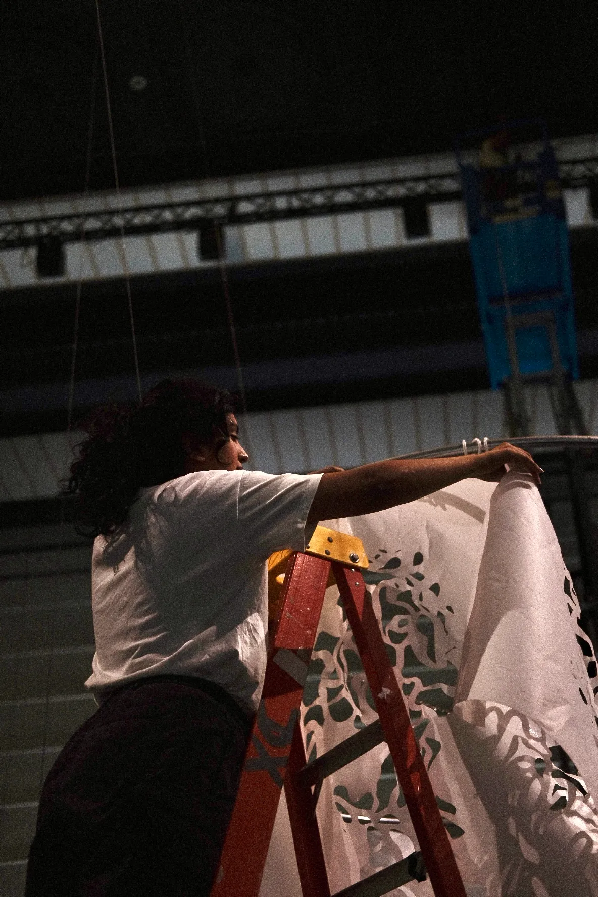Installing hand-cut paper from a ladder